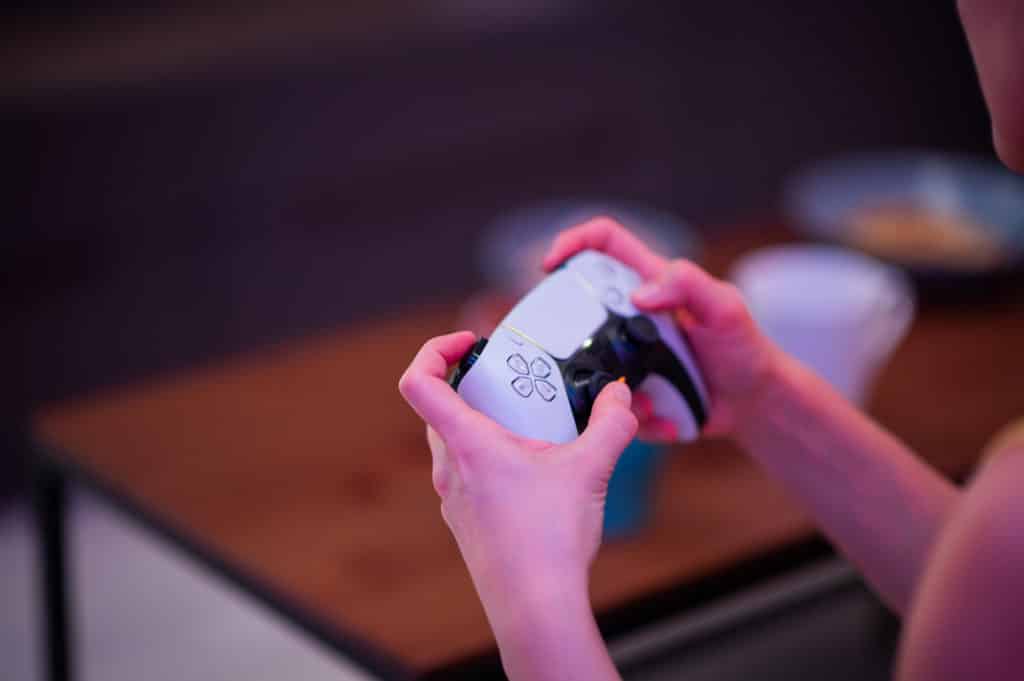 Girl with next gen controller in her hands playing games at home